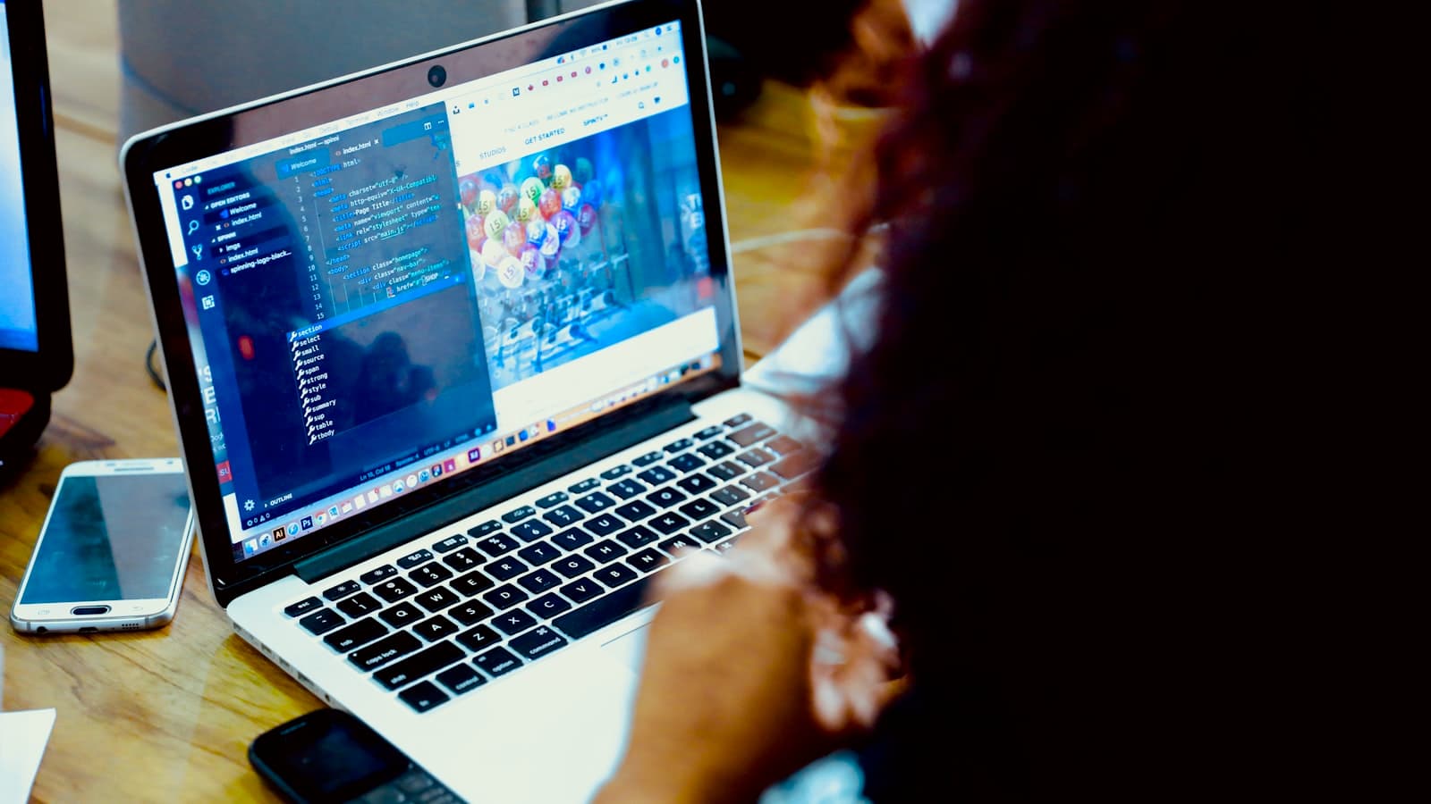 Working at a laptop with a phone alongside to capture task proof